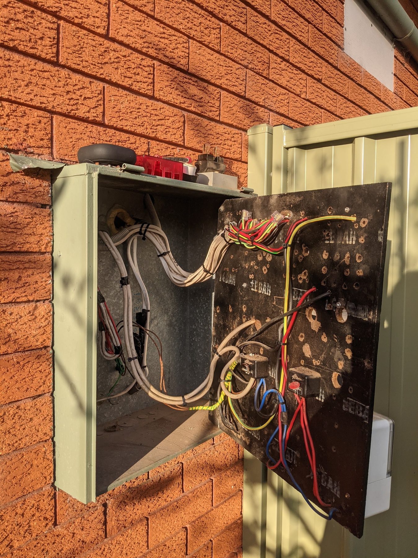 An old meter box opened up, with new cabling run in and bundled neatly
